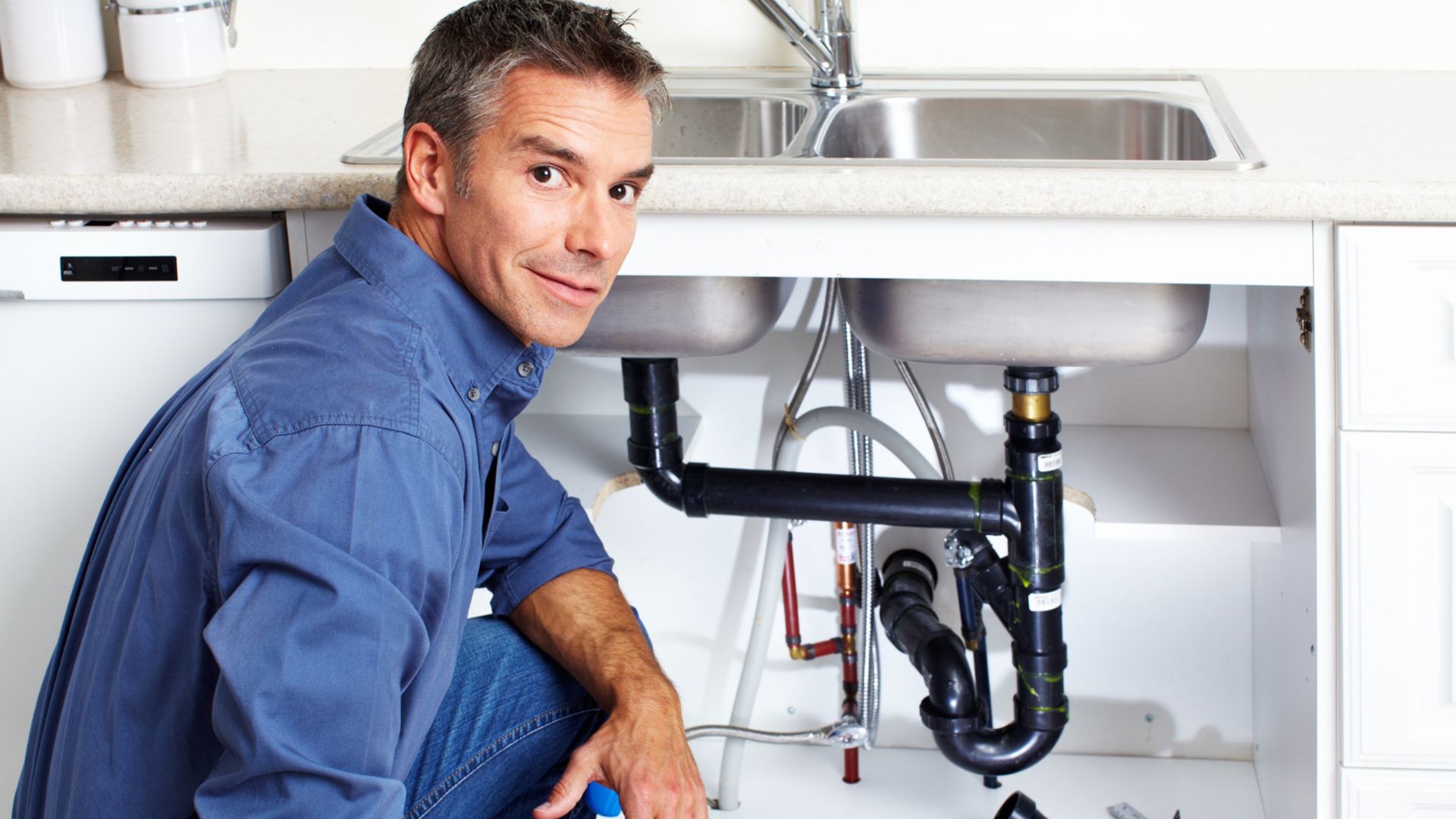 Plumber fixing pipe at night with AI handling incoming calls