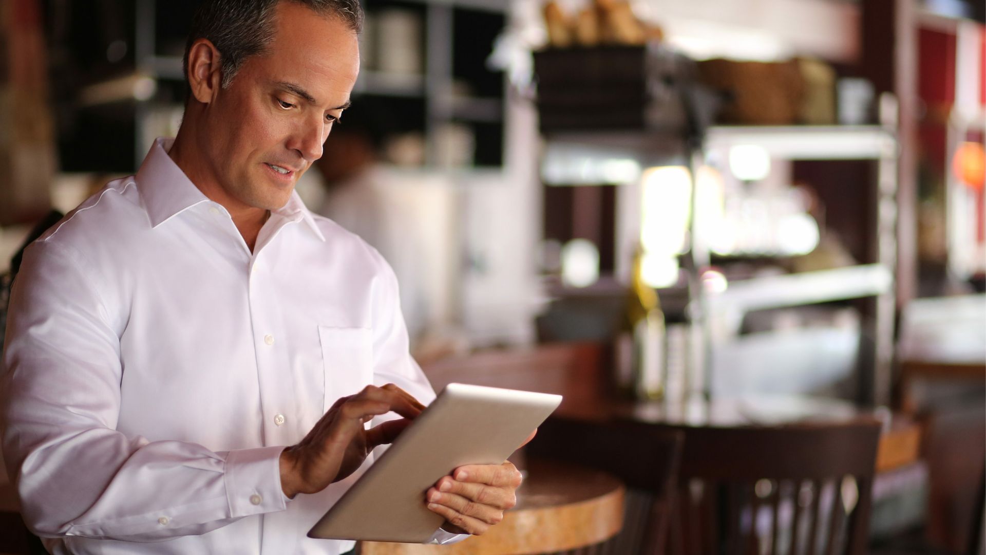 Restaurant host using AI reservation system on tablet